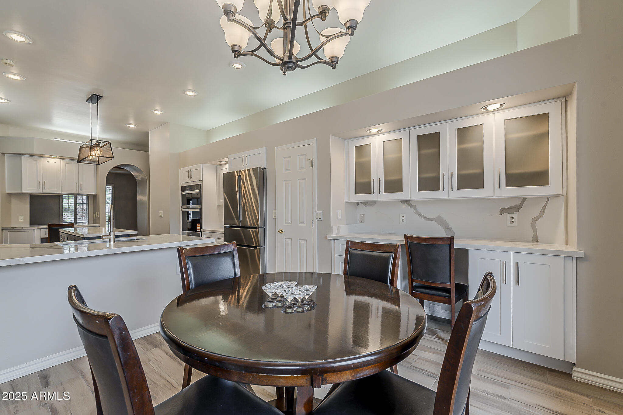 5345 East McLellan Road, Unit 112 Mesa, AZ 85205 - Photo 31 of 74 a kitchen with stainless steel appliances kitchen island granite countertop a dining table chairs and a refrigerator