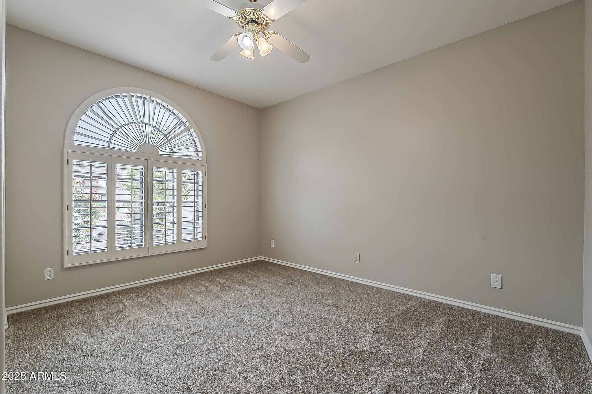 5345 East McLellan Road, Unit 112 Mesa, AZ 85205 - Photo 33 of 74 an empty room with a chandelier fan and windows