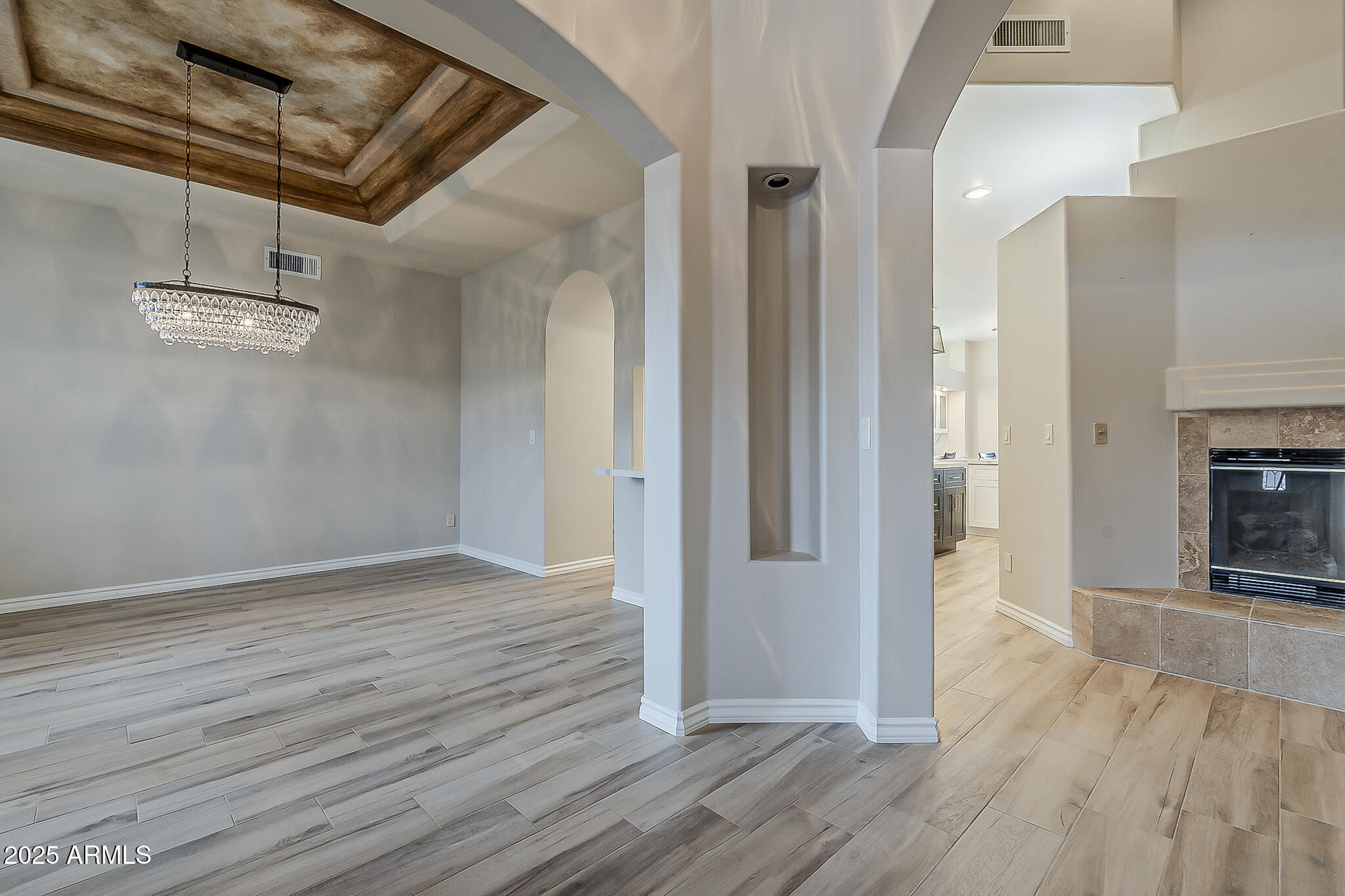 5345 East McLellan Road, Unit 112 Mesa, AZ 85205 - Photo 4 of 74 an empty room with wooden floor a fireplace and windows