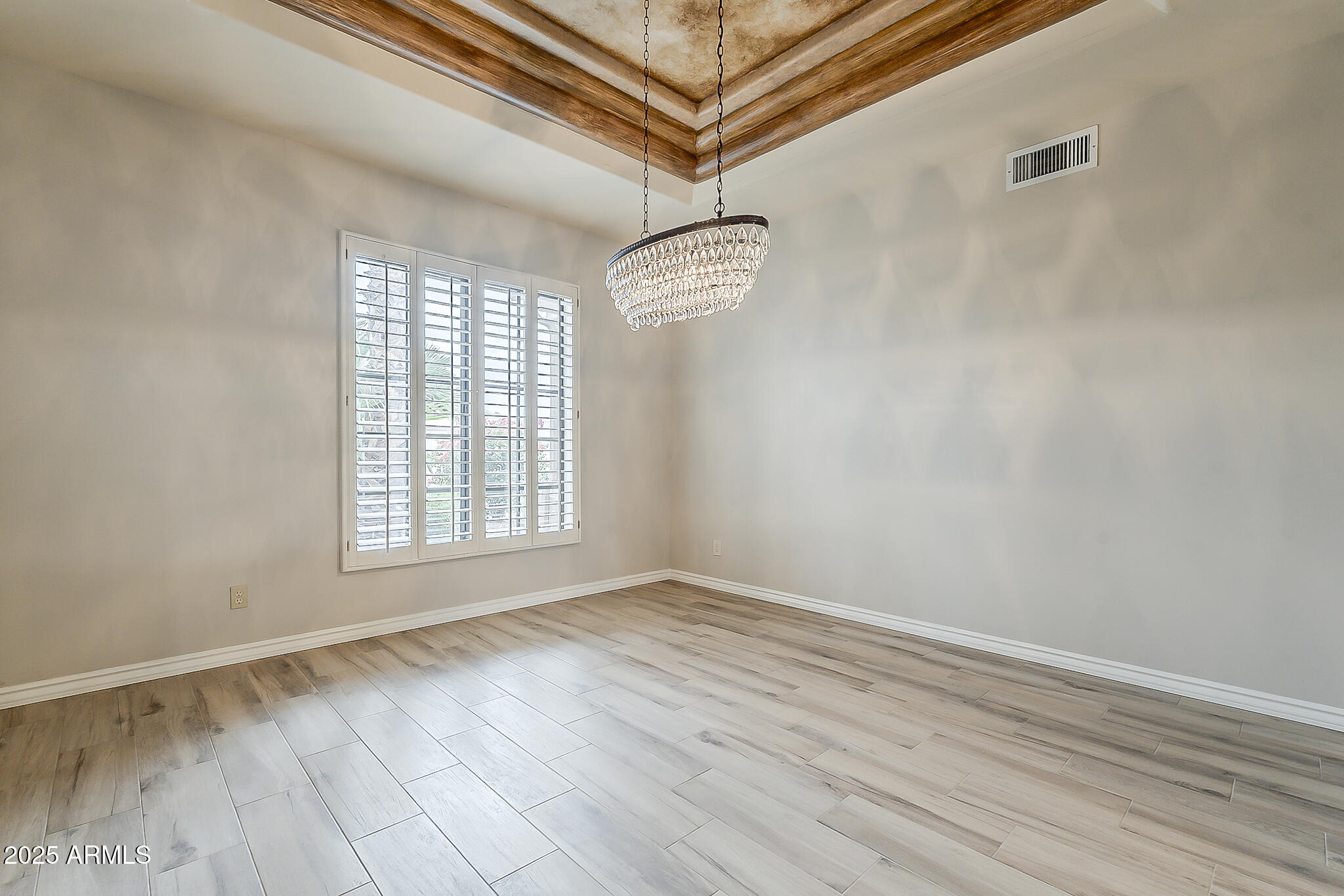 5345 East McLellan Road, Unit 112 Mesa, AZ 85205 - Photo 7 of 74 a view of an empty room with wooden floor and a window