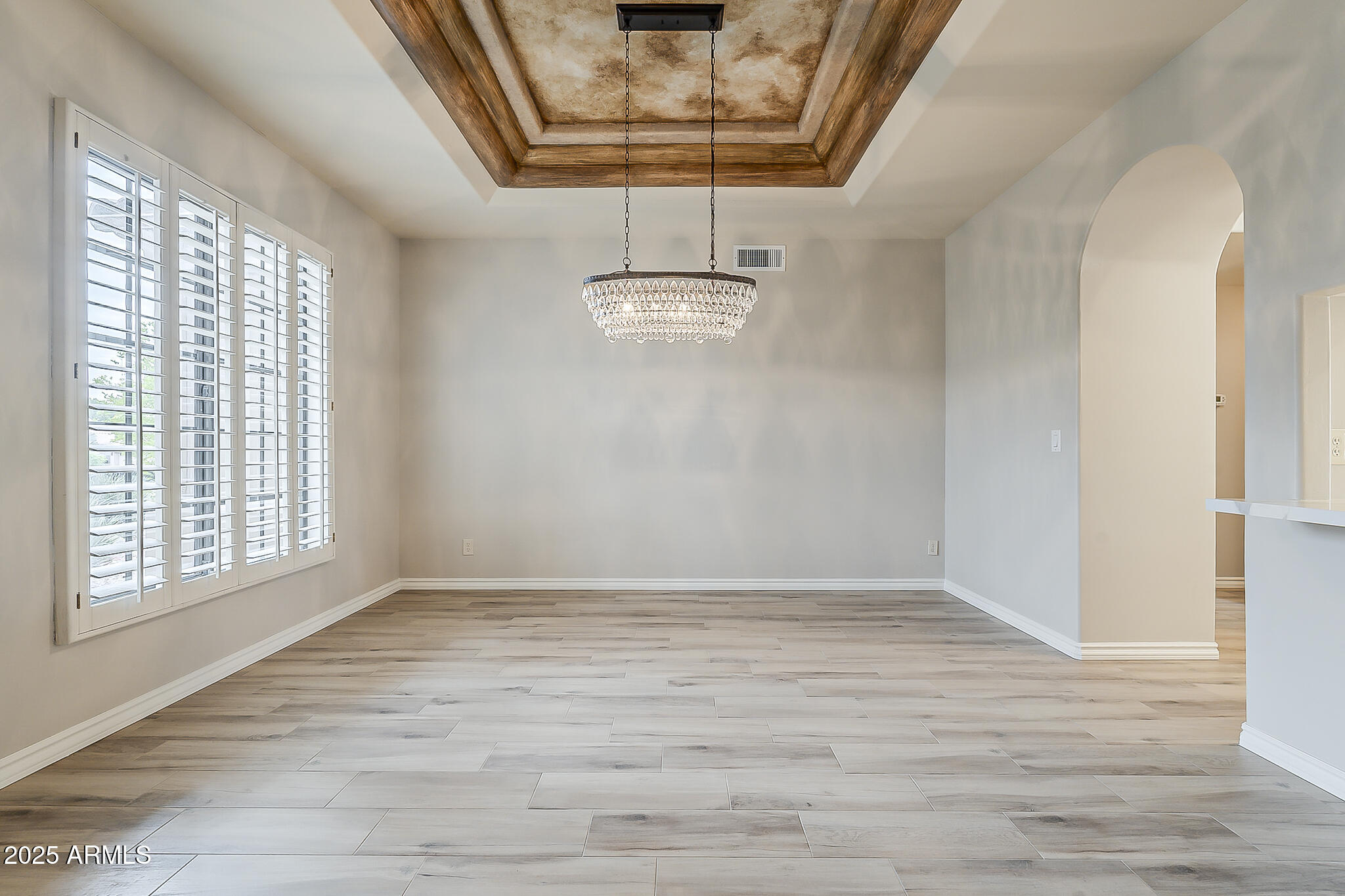5345 East McLellan Road, Unit 112 Mesa, AZ 85205 - Photo 8 of 74 a view of an empty room with wooden floor and a window