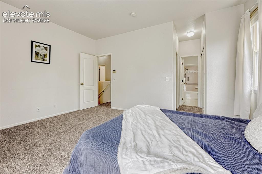 7285 Julynn Road Colorado Springs, CO 80919 - Photo 22 of 45 a bedroom with a bed and painting on the wall