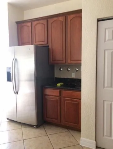 a kitchen with a refrigerator and cabinets
