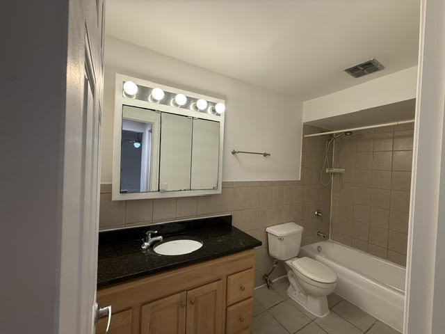 677 South River Road, Unit 2A Des Plaines, IL 60016 - Photo 14 of 15 a bathroom with a granite countertop toilet a sink and a shower