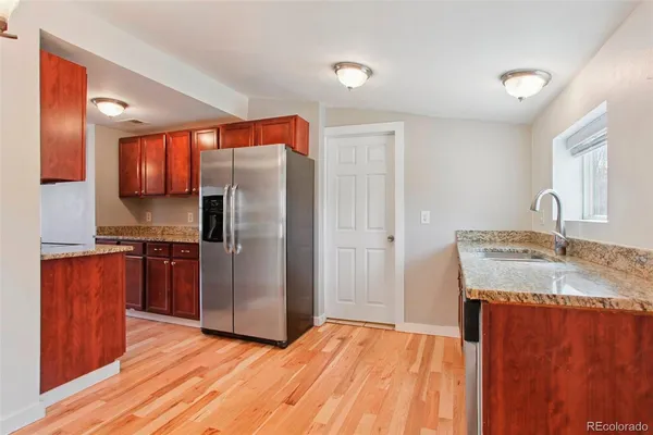 a kitchen with stainless steel appliances granite countertop a refrigerator and a sink