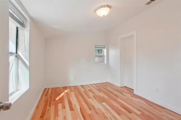 a view of empty room with wooden floor