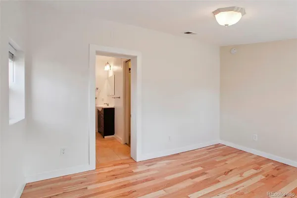 a view of empty room with wooden floor