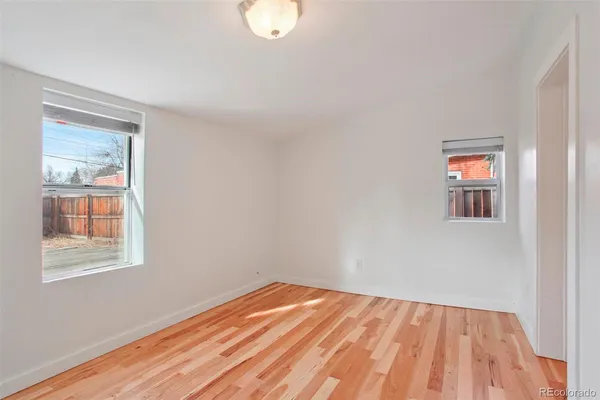 a view of a room with wooden floor and white walls