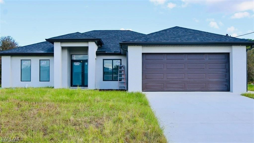 417 Progress Avenue Lehigh Acres, FL 33974 - Photo 1 of 25 a front view of house with yard