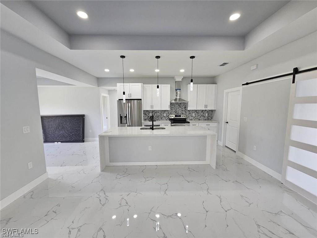 417 Progress Avenue Lehigh Acres, FL 33974 - Photo 19 of 25 a large white kitchen with a stove a refrigerator a sink dishwasher with a fireplace and cabinets