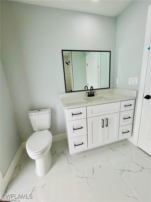 417 Progress Avenue Lehigh Acres, FL 33974 - Photo 10 of 25 a bathroom with a granite countertop toilet sink and mirror