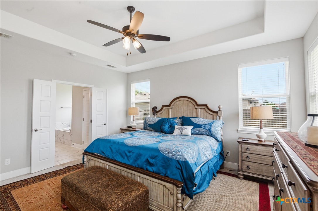 113 Terra Vista Ranch Road Victoria, TX 77904 - Photo 29 of 47 a bedroom with a bed and a chandelier