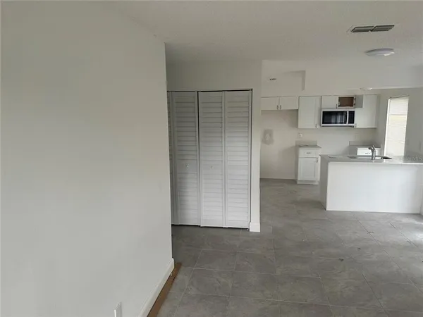 a view of a kitchen with refrigerator and a sink