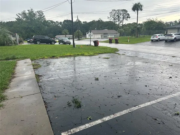 a view of a street with a car parked on the side of the road