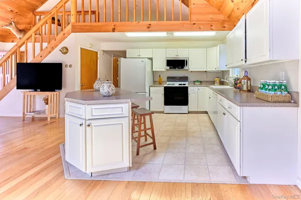 a kitchen with stainless steel appliances kitchen island granite countertop a refrigerator and a stove top oven