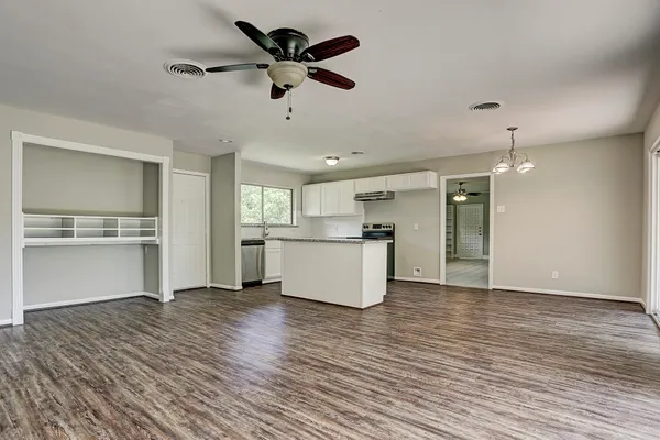 a view of kitchen with granite countertop cabinets and refrigerator