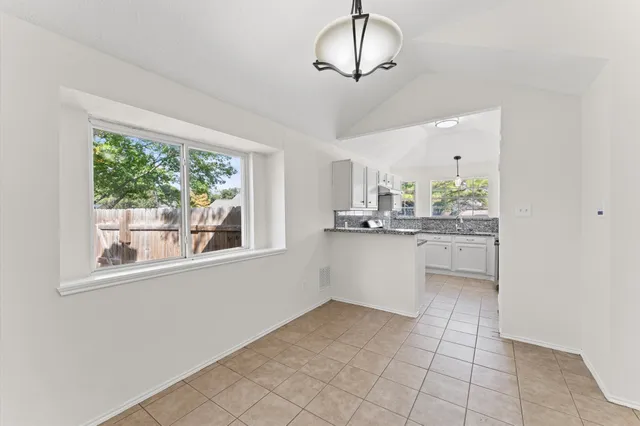 a kitchen with stainless steel appliances a counter space and a chandelier