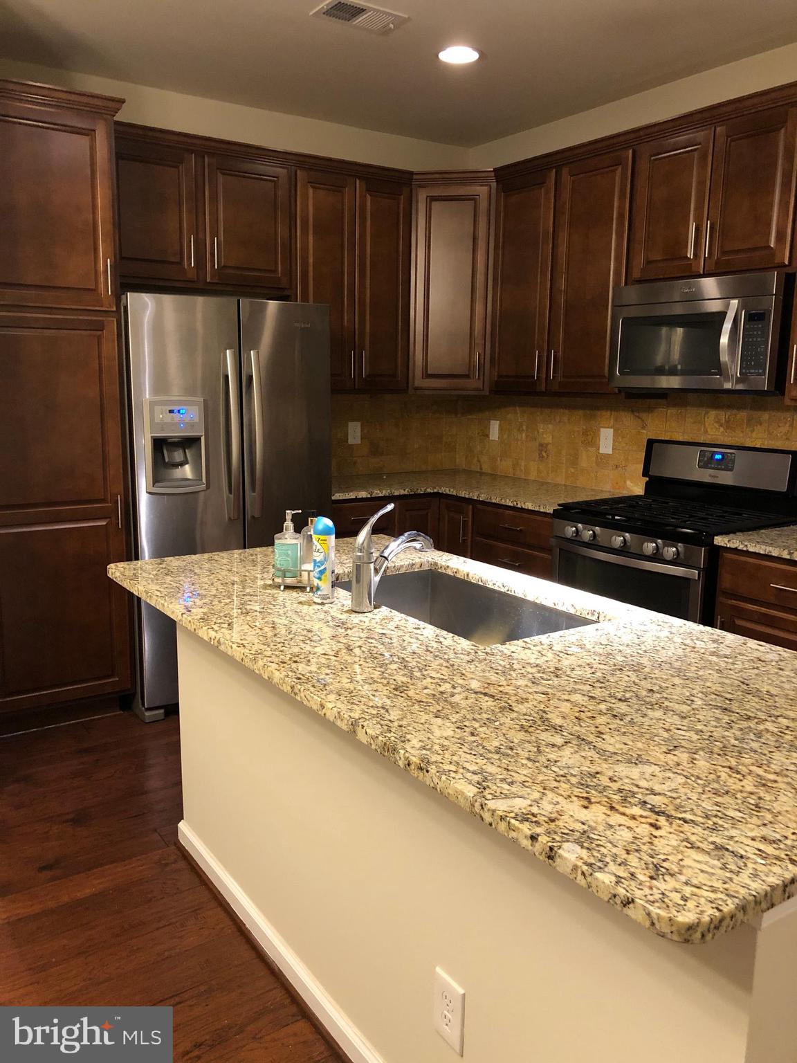 42797 Burrell Square Ashburn, VA 20147 - Photo 5 of 13 a kitchen with stainless steel appliances granite countertop a sink stove and refrigerator