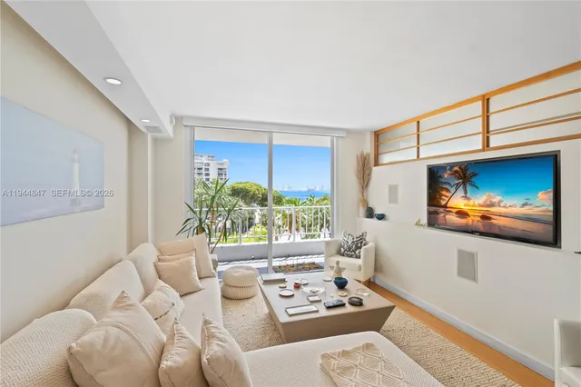 a living room with furniture a window and a flat screen tv