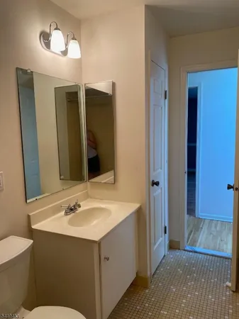 a bathroom with a sink mirror vanity and toilet