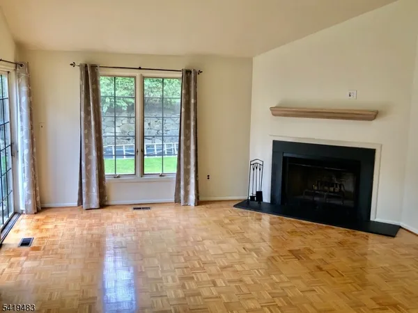 a view of an empty room with a fireplace and a window