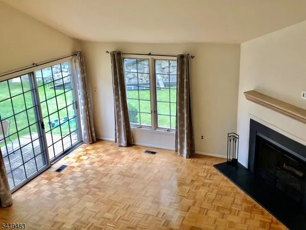 a view of an empty room with a fireplace and a window
