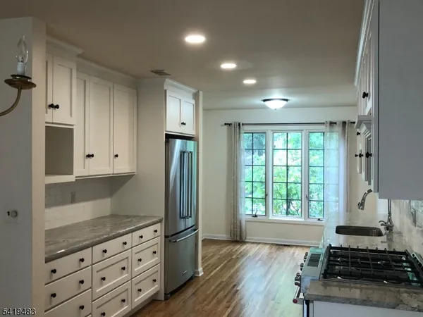 a kitchen with granite countertop a stove and a refrigerator