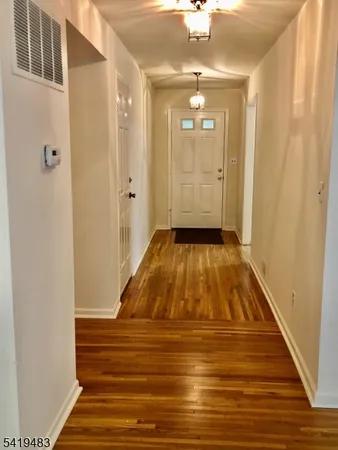 a view of a hallway with wooden floor and staircase