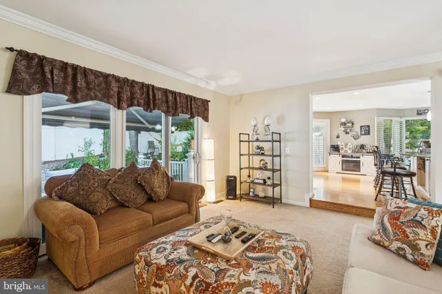 a very nice looking dining room with kitchen island furniture a large window and a view of living room