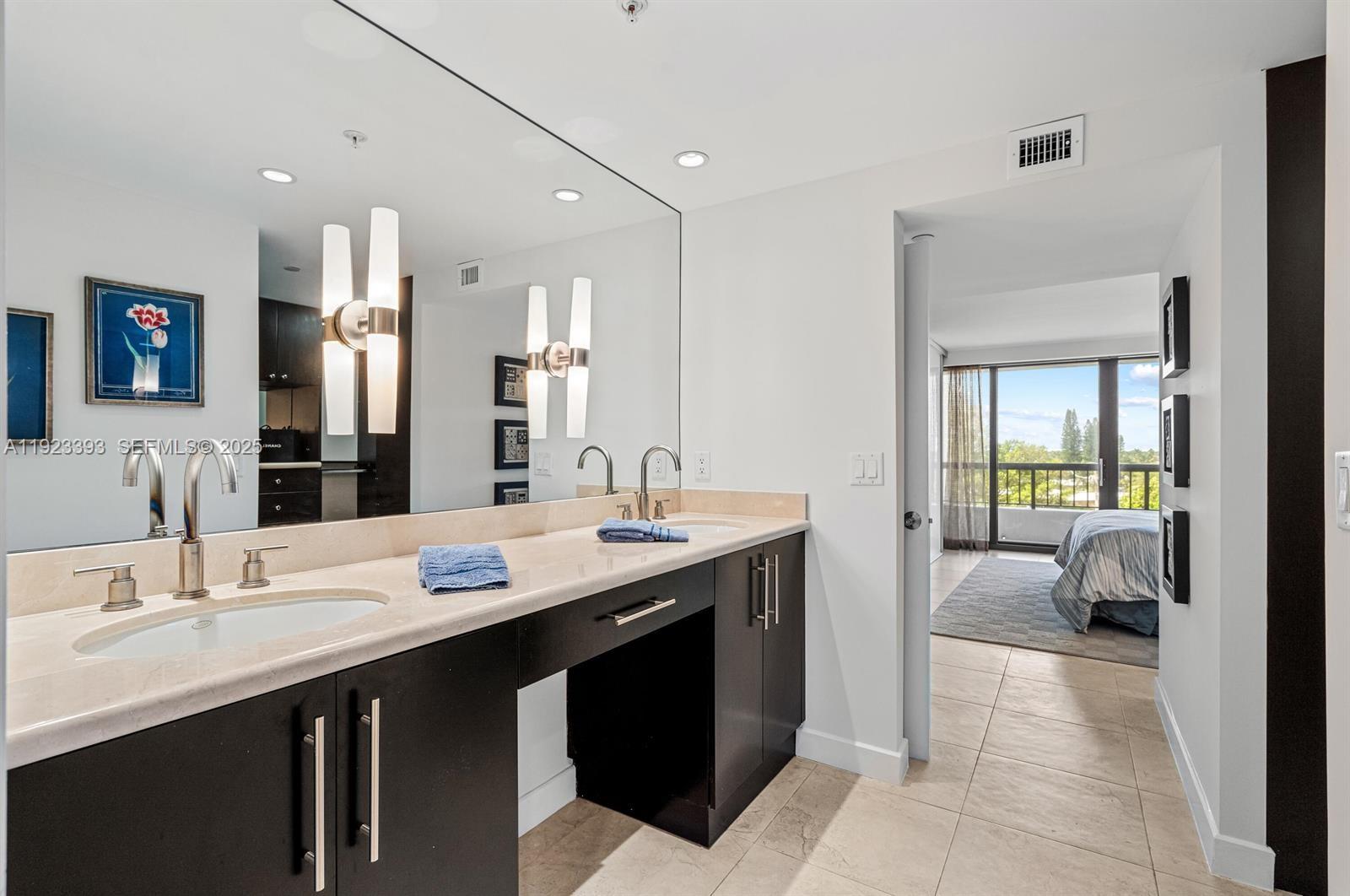 1800 South Ocean Boulevard, Unit 5C Boca Raton, FL 33432 - Photo 18 of 98 a en suite bathroom with a double vanity sink a mirror and a