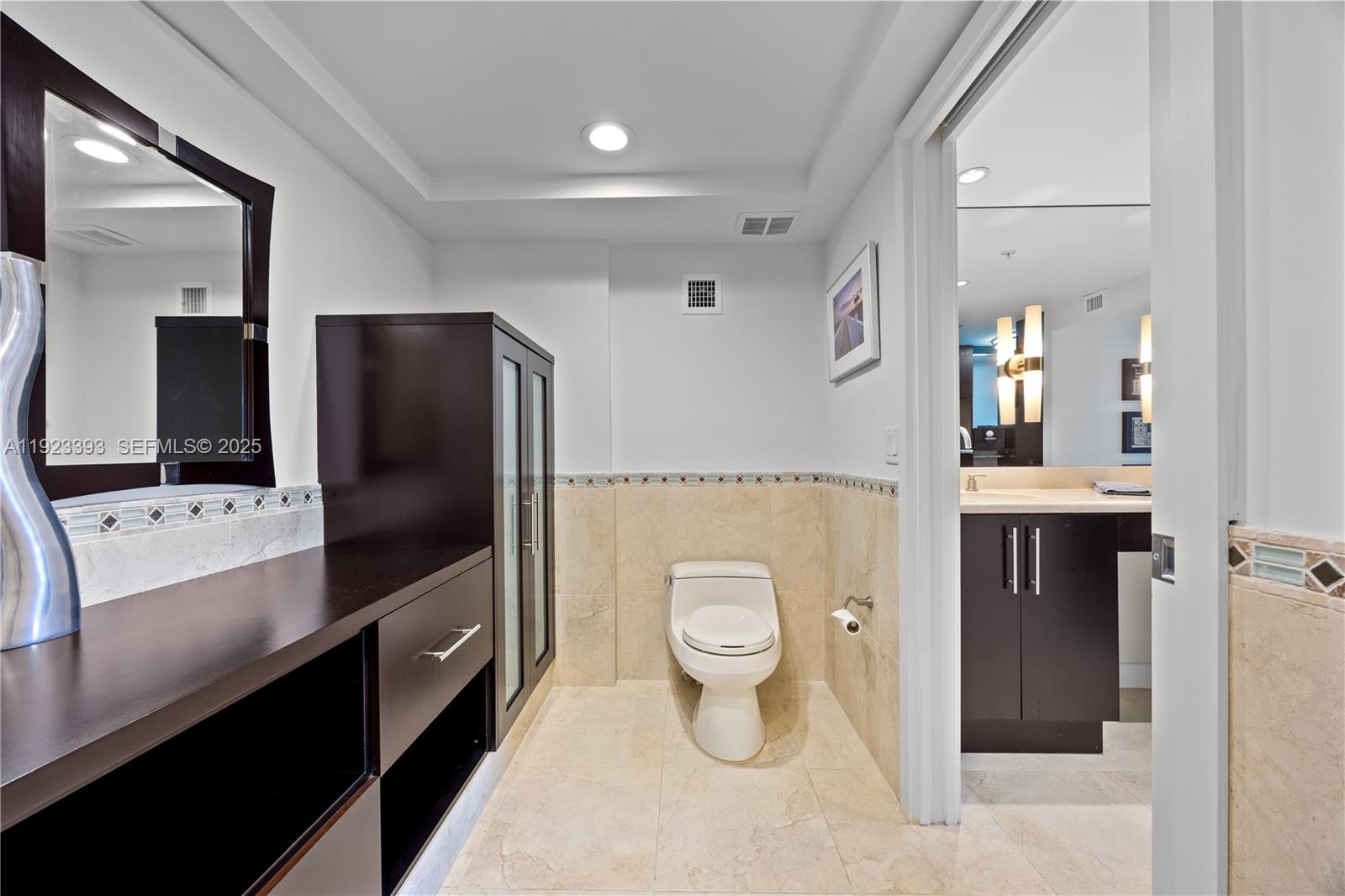 1800 South Ocean Boulevard, Unit 5C Boca Raton, FL 33432 - Photo 81 of 98 a bathroom with a toilet sink and mirror