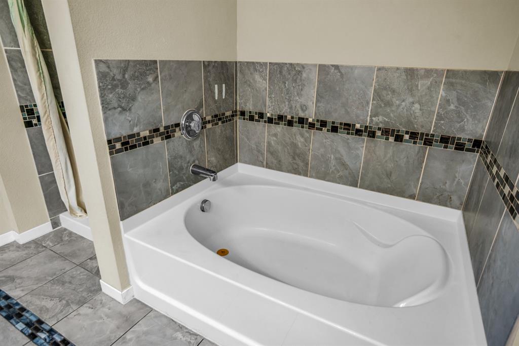 5718 Green Ivy Road Denton, TX 76210 - Photo 21 of 37 Built-in soaking tub featuring a chrome faucet and drain