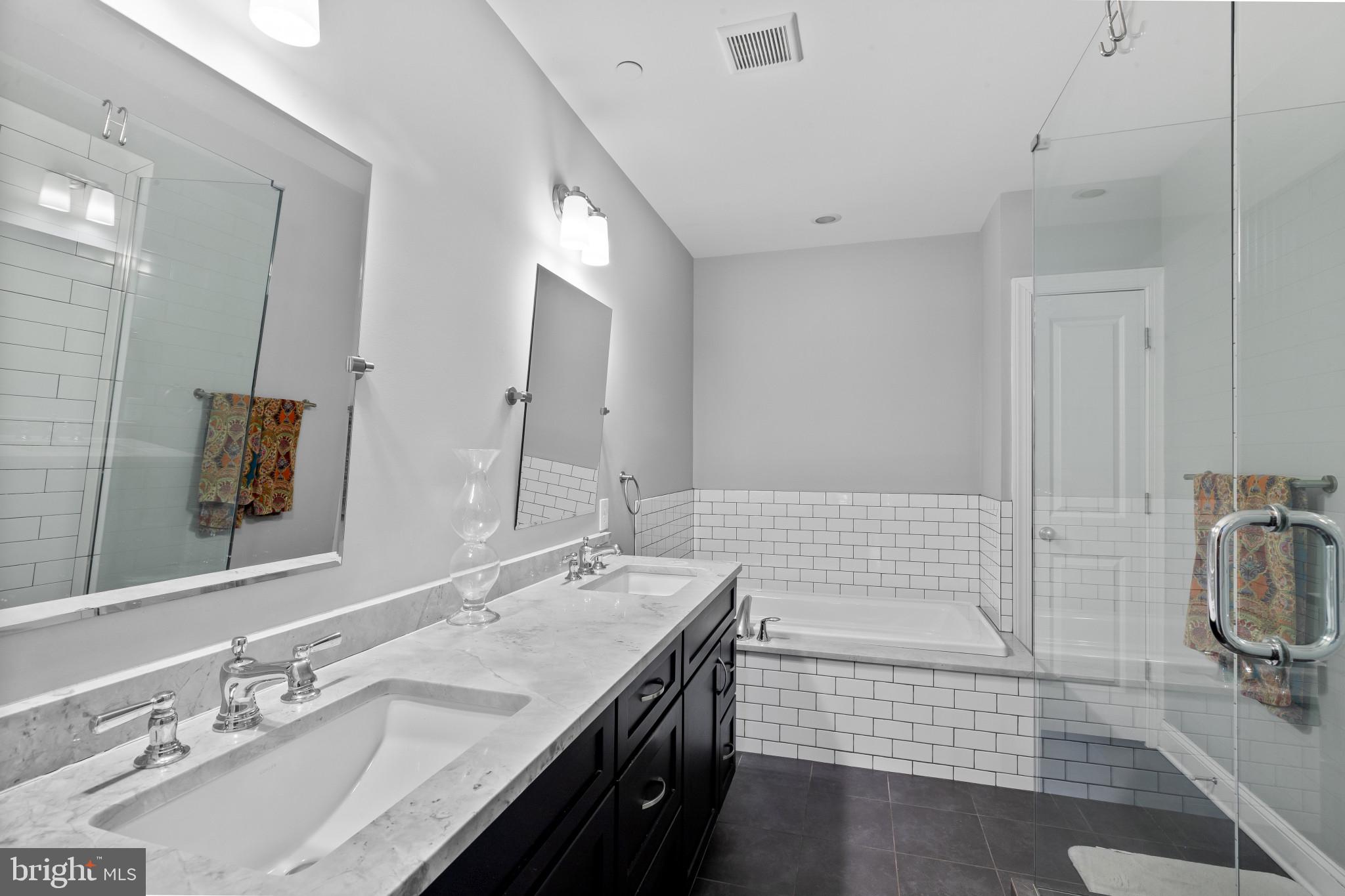 3800 Dillon Street Baltimore, MD 21224 - Photo 15 of 34 a bathroom with a double vanity sink a mirror and bathtub