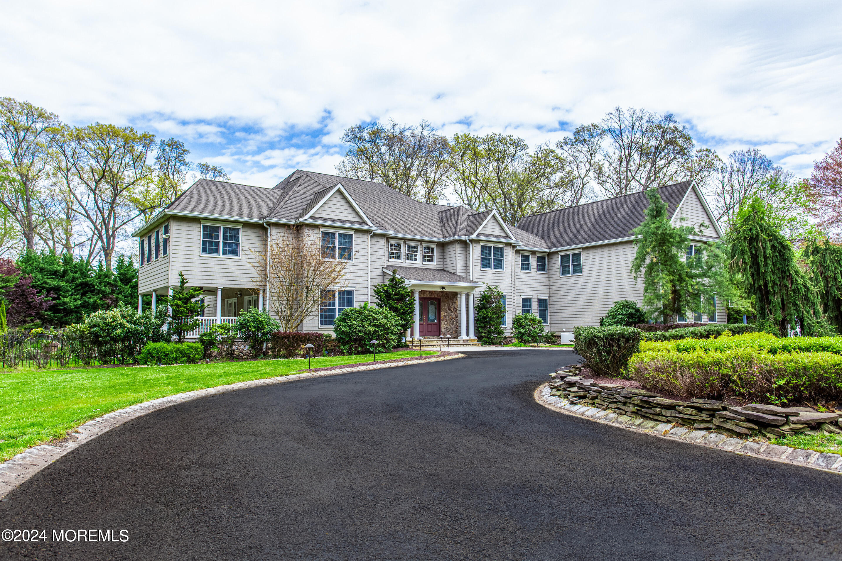 25 Woods End Road Colts Neck, NJ 07722 - Photo 2 of 76 a front view of a house with a garden and trees