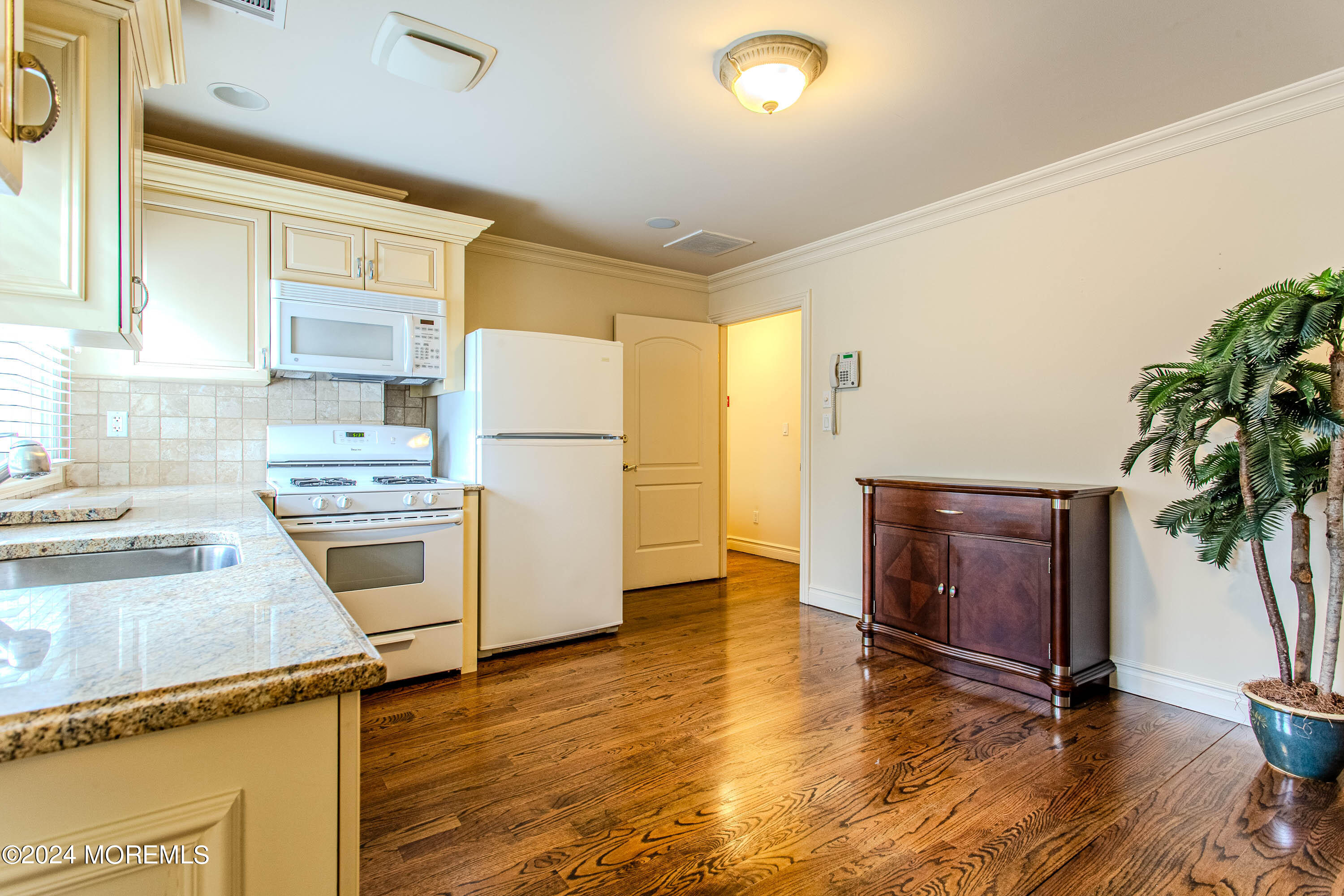 25 Woods End Road Colts Neck, NJ 07722 - Photo 54 of 76 a kitchen with granite countertop a refrigerator a stove a sink and dishwasher with wooden floor