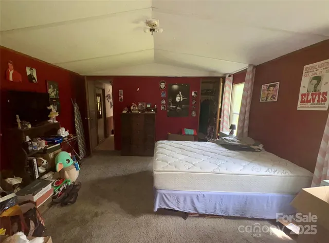 a bedroom with a bed a mirror and lamp