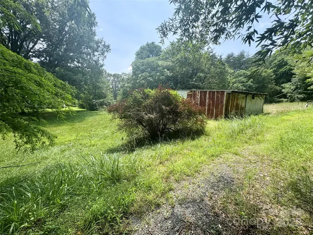 a backyard of a house with lots of green space and garden