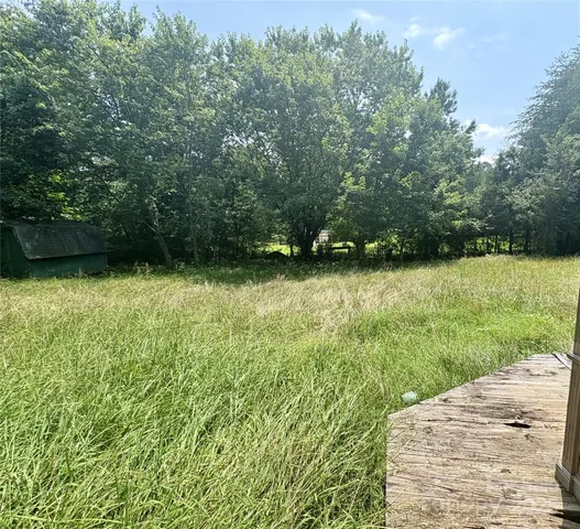 a backyard of a house with lots of green space and fountain