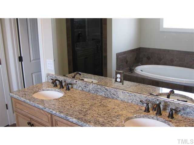 10115 2nd Star Court Raleigh, NC 27613 - Photo 18 of 25 Granite countertops on your dual vanity, a custom tile shower and whirlpool, and elegant oil rubbed bronze fixtures...what a space to wash away the worries of the day! Master Bath/Spa