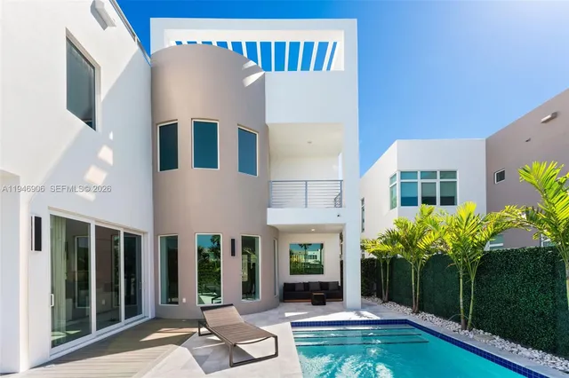 a view of a house with swimming pool and sitting area