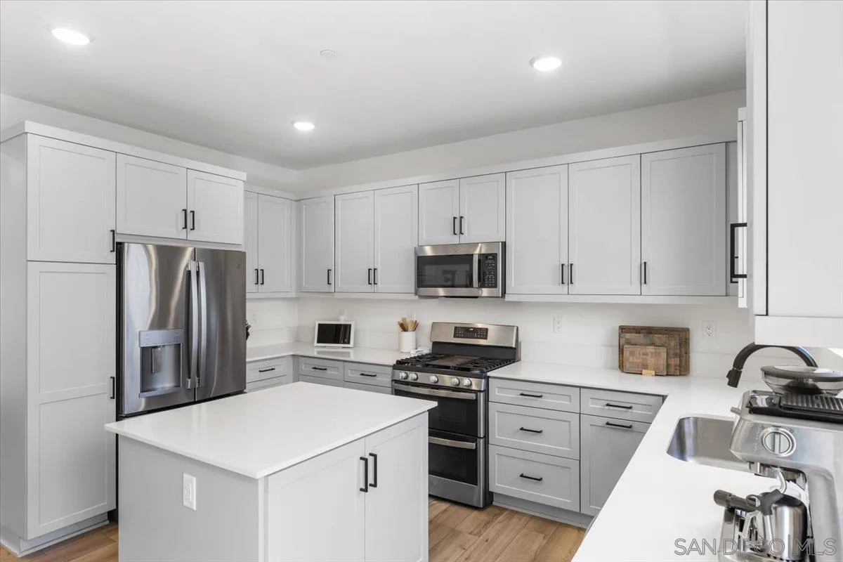 108 Lipizzan Lane Fallbrook, CA 92028 - Photo 11 of 37 a kitchen with white cabinets and stainless steel appliances