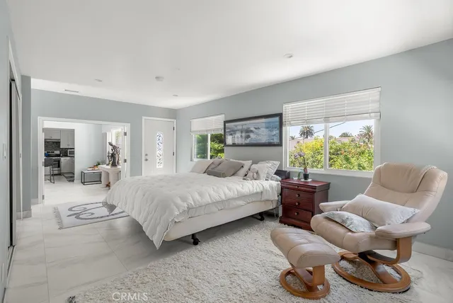 a bedroom with furniture and a large window