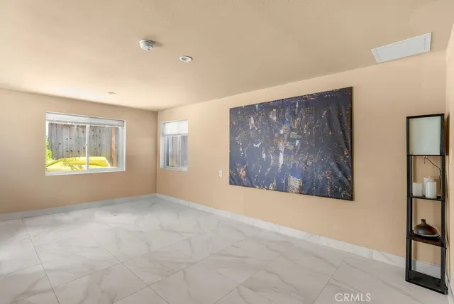 an empty room with windows and cabinet