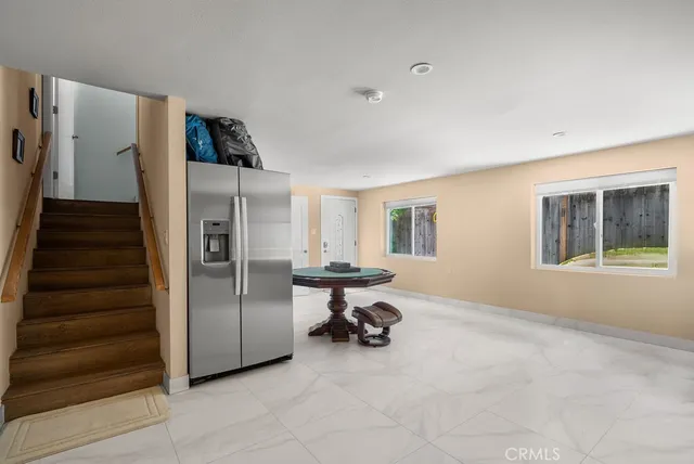 a kitchen with stainless steel appliances kitchen island granite countertop a refrigerator and a sink