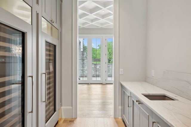 a view of a hallway with wooden floor and a chandelier