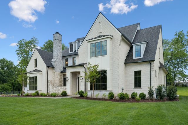 a front view of a house with a garden and plants