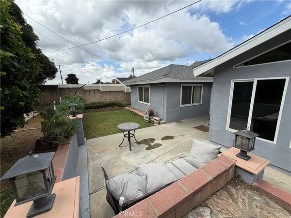 a view of a patio with couches table and chairs with wooden floor and fence
