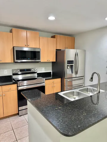 a kitchen with stainless steel appliances granite countertop a sink a microwave cabinets and a counter top space