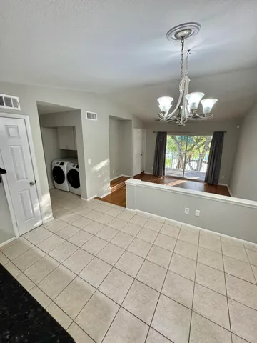 a spacious bedroom with a large bed and a chandelier