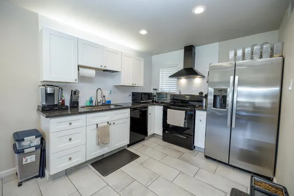 a kitchen with granite countertop stainless steel appliances and white cabinets